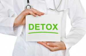 Doctor holding a card with DETOX, Medical concept