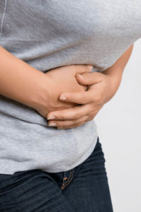 female experiencing stomach pain, symptoms of ibs